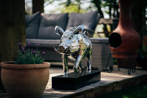 A fierce boar, glinting in polished stainless steel, stands strong.