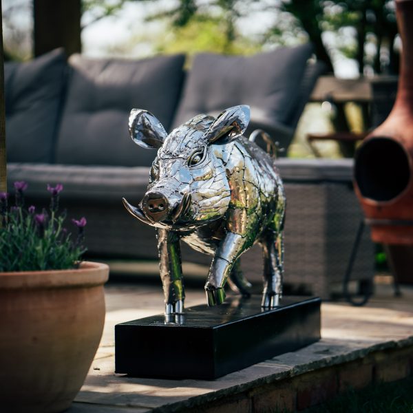 A fierce boar, glinting in polished stainless steel, stands strong.