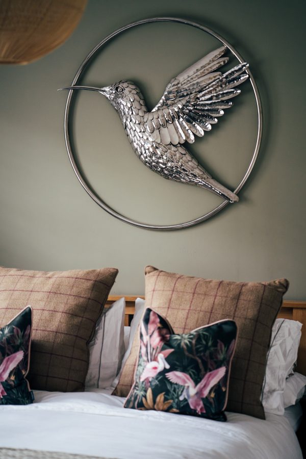 A hummingbird takes flight on your walls, crafted from gleaming stainless steel.