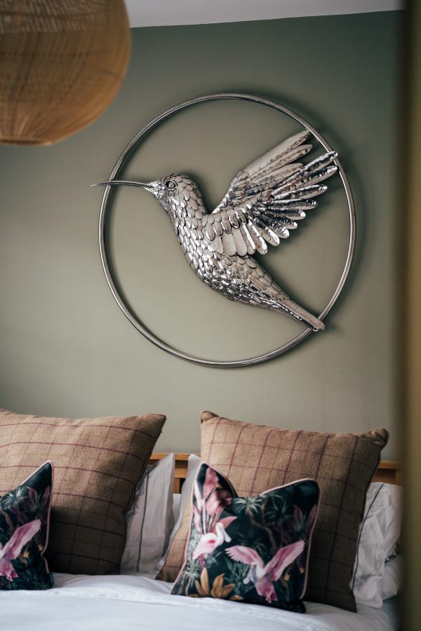 A lifelike hummingbird, seemingly in flight, adorns your wall in this stainless steel artwork.