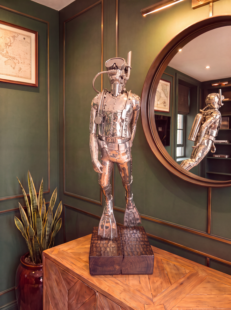 Scuba Diver statue in stainless steel, sitting on hard wooden plinth.